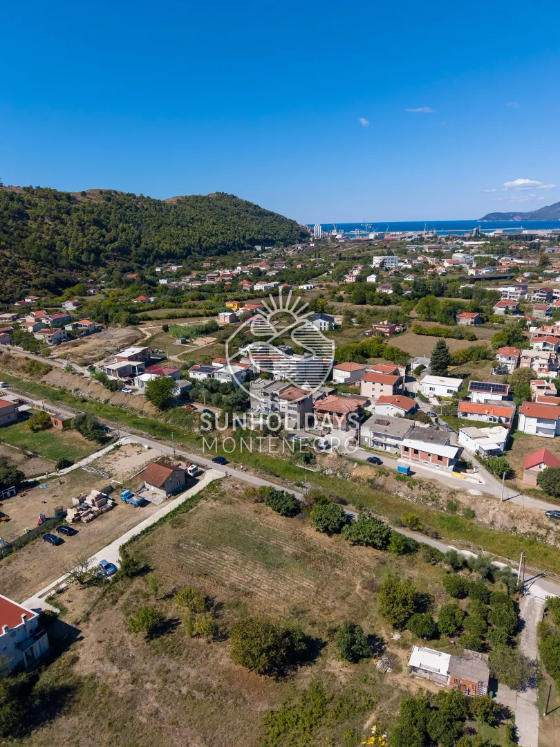 Pogled iz vazduha na naselje i okolni pejzaž.