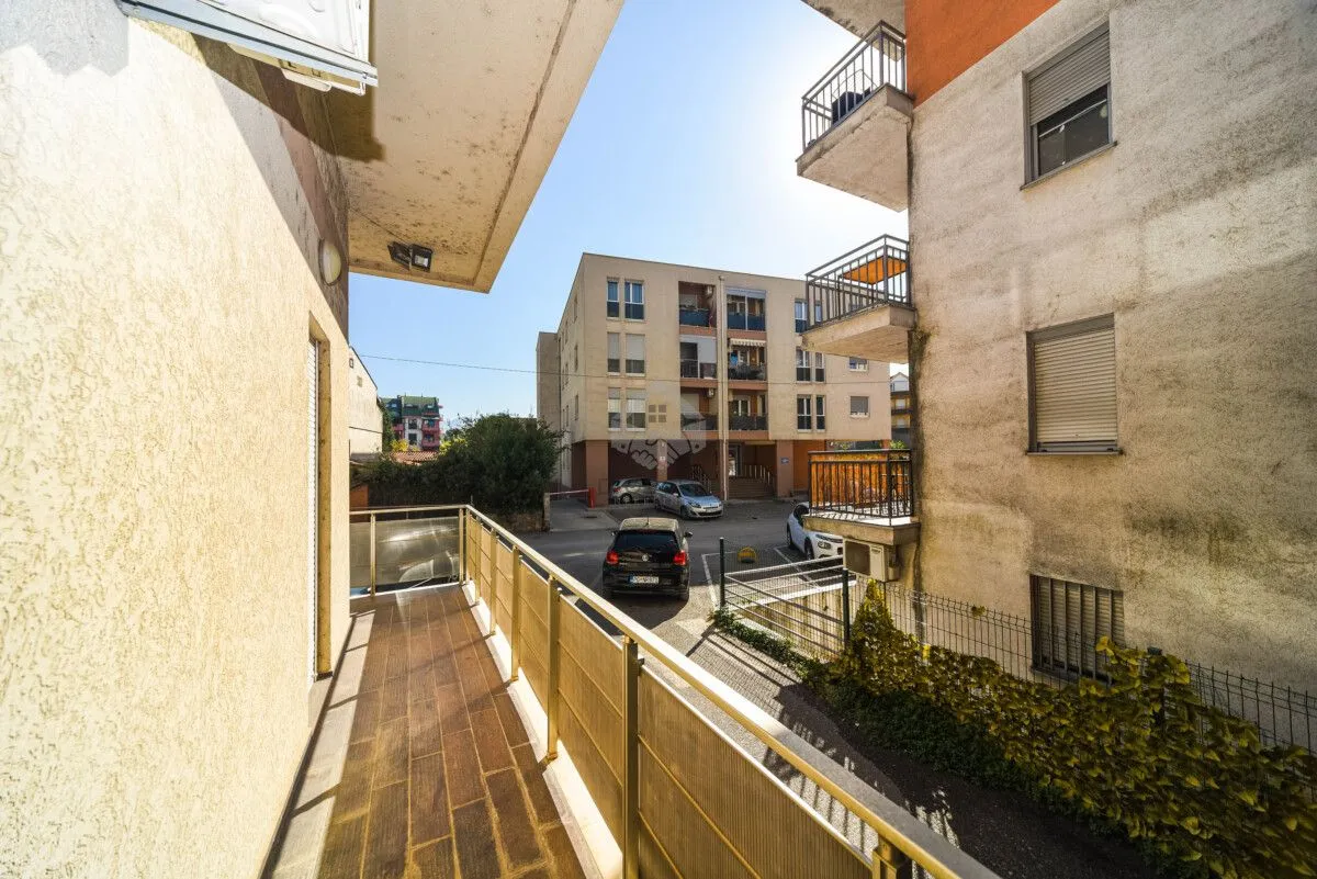 View from the balcony overlooking buildings and parking.