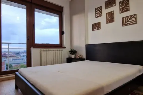 Furnished bedroom with a double bed, window, and city view. - image 5