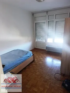 Smaller bedroom with a bed and access to the terrace. - image 10