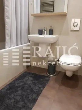Modern bathroom with a sink, toilet, and bathtub. - image 13