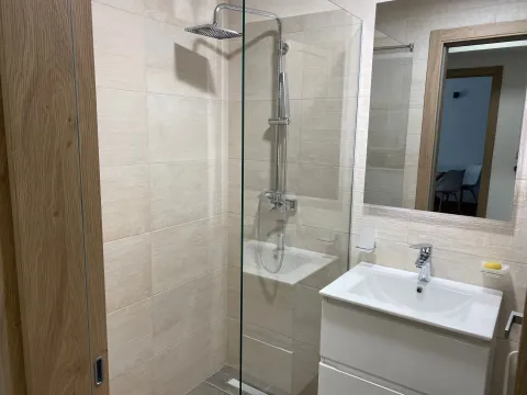 Modern bathroom with a walk-in shower and vanity unit. - image 9