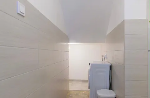Small tiled bathroom with a washing machine. - image 6