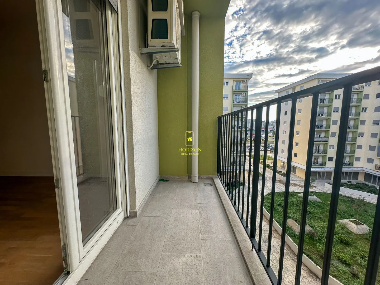 Prostrana terasa sa pogledom na susjedne zgrade i dvorište.