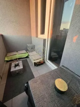 Manji namešten balkon sa stolom i jastucima za sedenje. - image 11