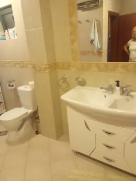 Bright bathroom with a vanity sink and toilet. - image 11