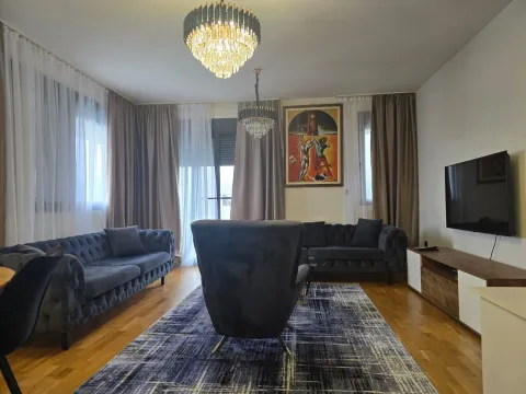 Prostrana dnevna soba sa garniturom za sjedenje, televizorom i trpezarijskim stolom. - image 4