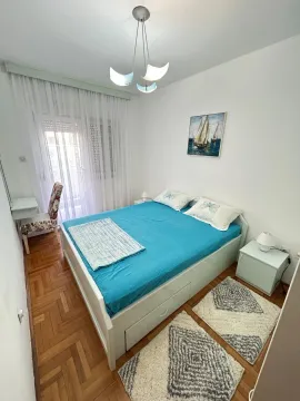 Namještena spavaća soba sa bračnim krevetom, radnim stolom i izlazom na terasu. - image 3