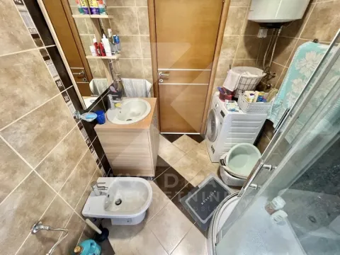 Small bathroom with a sink, washing machine, bidet, and shower cabin. - image 9