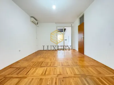 Prazna soba sa parketom i izlazom na terasu.