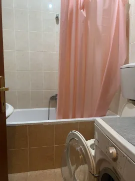 Bathroom with a bathtub and a washing machine. - image 7