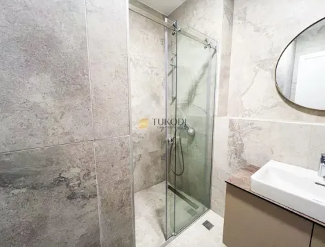 Modern bathroom with a glass-enclosed shower and a washbasin. - image 9