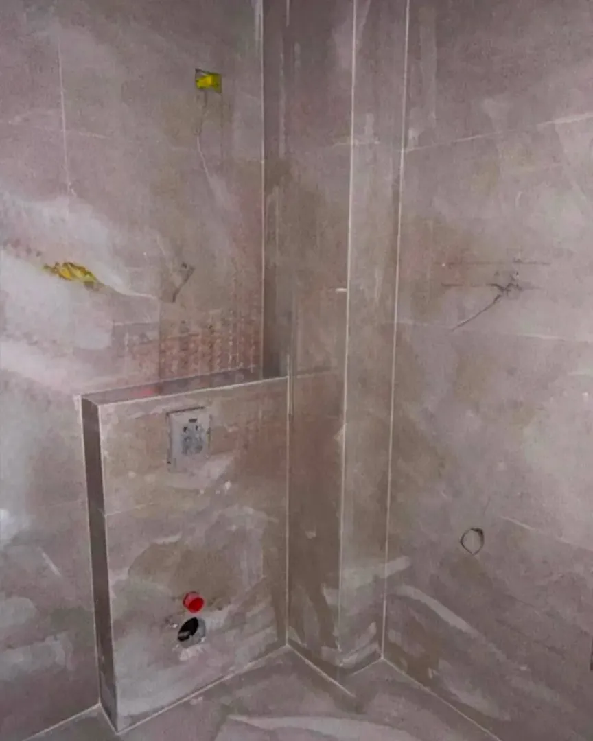 Bathroom under finishing works with installed tiles.