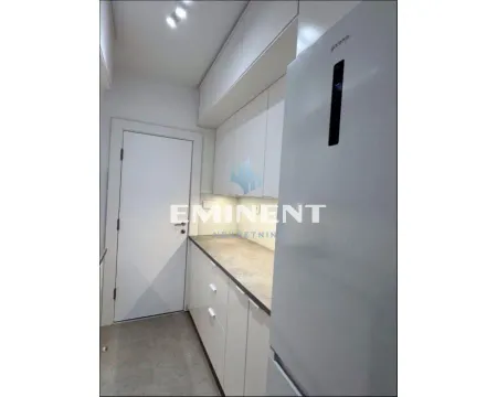Modern kitchen with white cabinetry and a refrigerator. - image 6