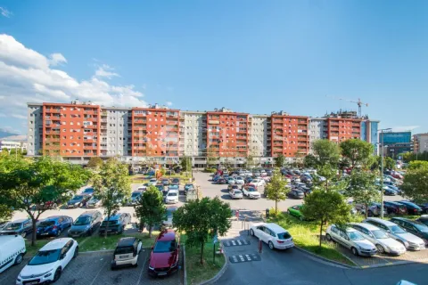 Pogled sa visine na stambenu zgradu i veliki parking ispred objekta. - image 13