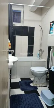 Kupatilo opremljeno kadom, umivaonikom i toaletom sa crno-belim pločicama. - image 10