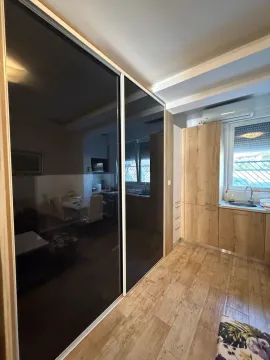 Manja kuhinja sa drvenim elementima i velikim kliznim ormarom u hodniku. - image 3