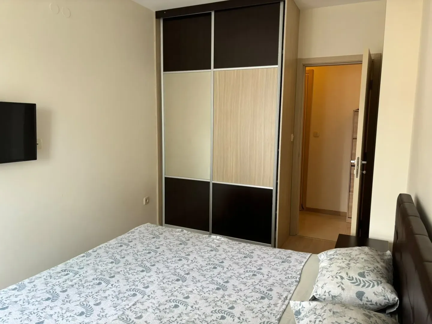 Furnished bedroom with a large wardrobe and a double bed.
