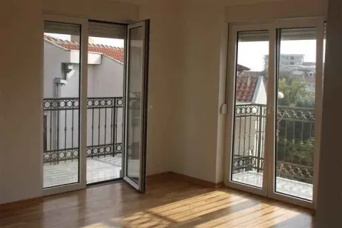 Empty room with wooden flooring and two balcony doors. - image 5