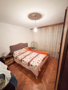 Spavaća soba sa bračnim krevetom, noćnim ormarićem i parketom na podu. - image 4