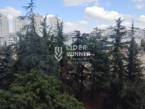 View from the apartment overlooking surrounding greenery and buildings. - image 17