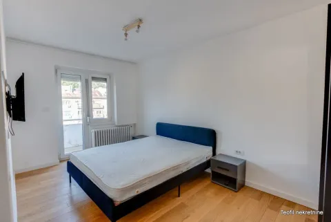 Spavaća soba sa bračnim krevetom, noćnim ormarićem i izlazom na terasu. - image 5
