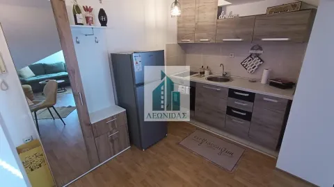 Compact kitchen with wooden cabinetry and refrigerator, connected to the living area. - image 14