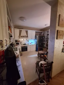 A spacious kitchen with white cabinets and a dining table. - image 11