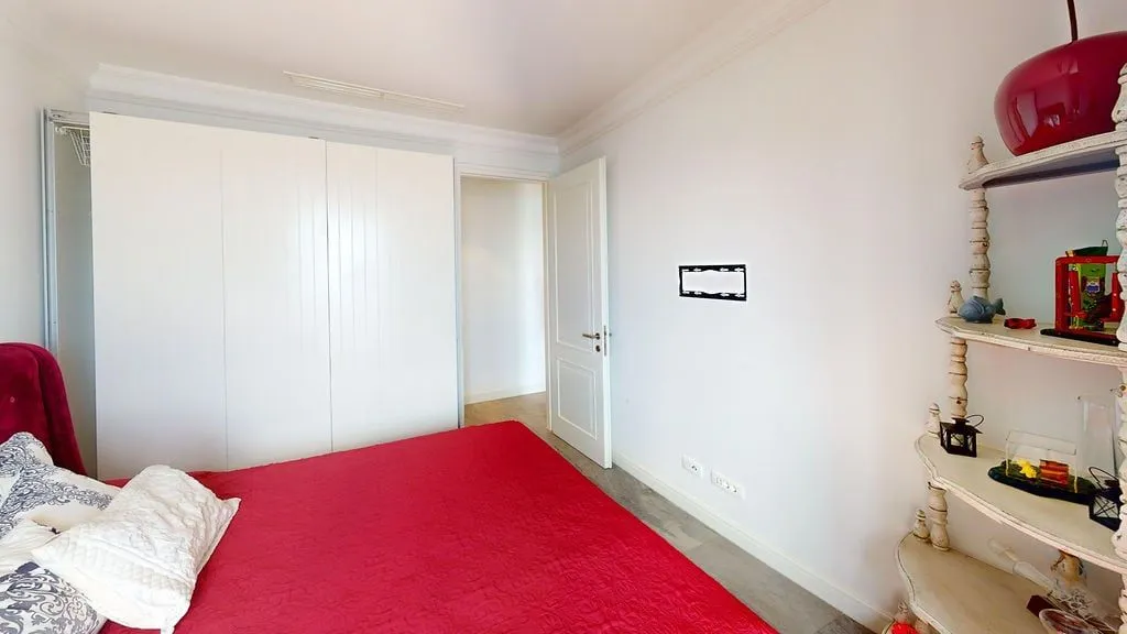 Svijetla spavaća soba sa velikim krevetom i bijelim plakarem.