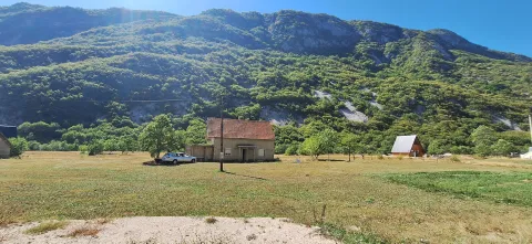 Pogled na kuću sa dvorištem i brdima u pozadini. - image 6