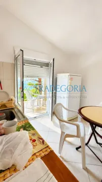 Smaller kitchen with a dining table and access to the terrace. - image 5