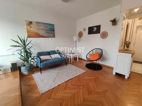 Dnevna soba sa garniturom, parketom i dekorativnim detaljima na zidu. - image 7