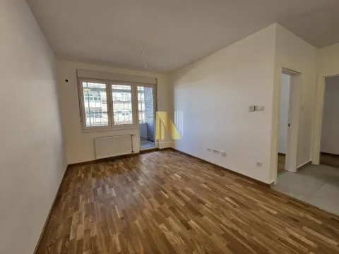 Prazna soba sa parketom i prozorom koji gleda na terasu. - image 3