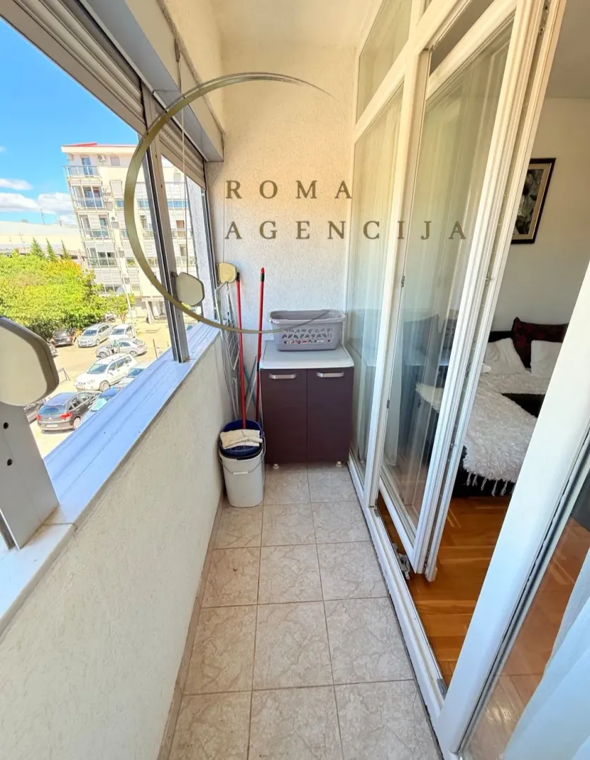 Small enclosed balcony with storage units and a street view.