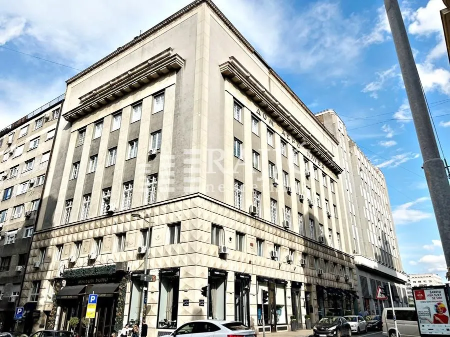 Exterior view of a residential and commercial building with a street in the foreground.
