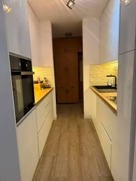 Moderna bijela kuhinja sa drvenim radnim površinama i ugradnim elementima. - image 3