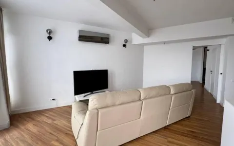 Dnevna soba sa svijetlim zidovima, kožnim trosjedom i televizorom. - image 2