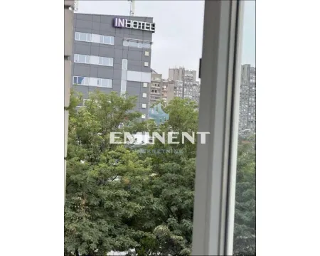 View from the apartment overlooking surrounding buildings and greenery. - image 11