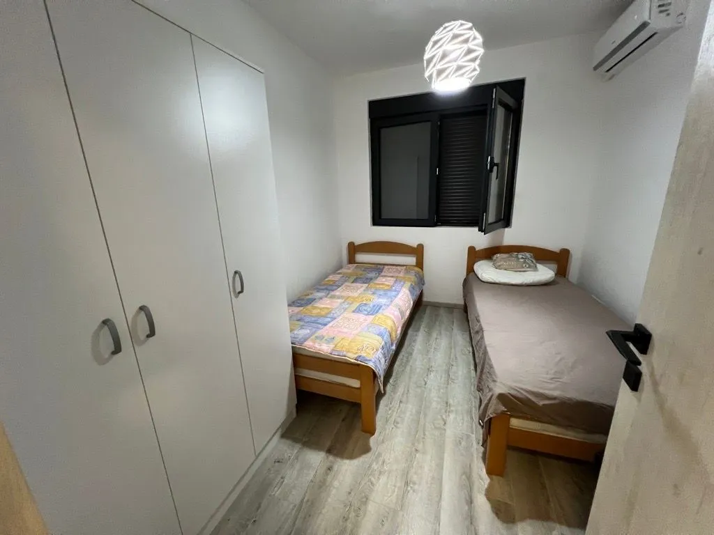 Small bedroom with two single beds and a built-in wardrobe.