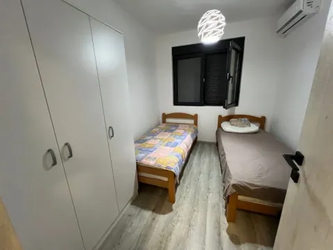 Small bedroom with two single beds and a built-in wardrobe. - image 8