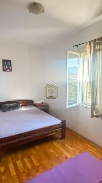 Spavaća soba sa bračnim krevetom i prozorom koji gleda spolja. - image 5