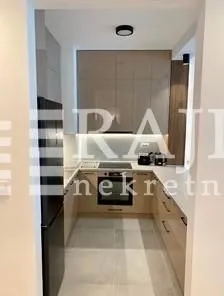 Moderna i uredna kuhinja sa ugradnim elementima.