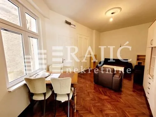 Living room with a dining area and parquet flooring.