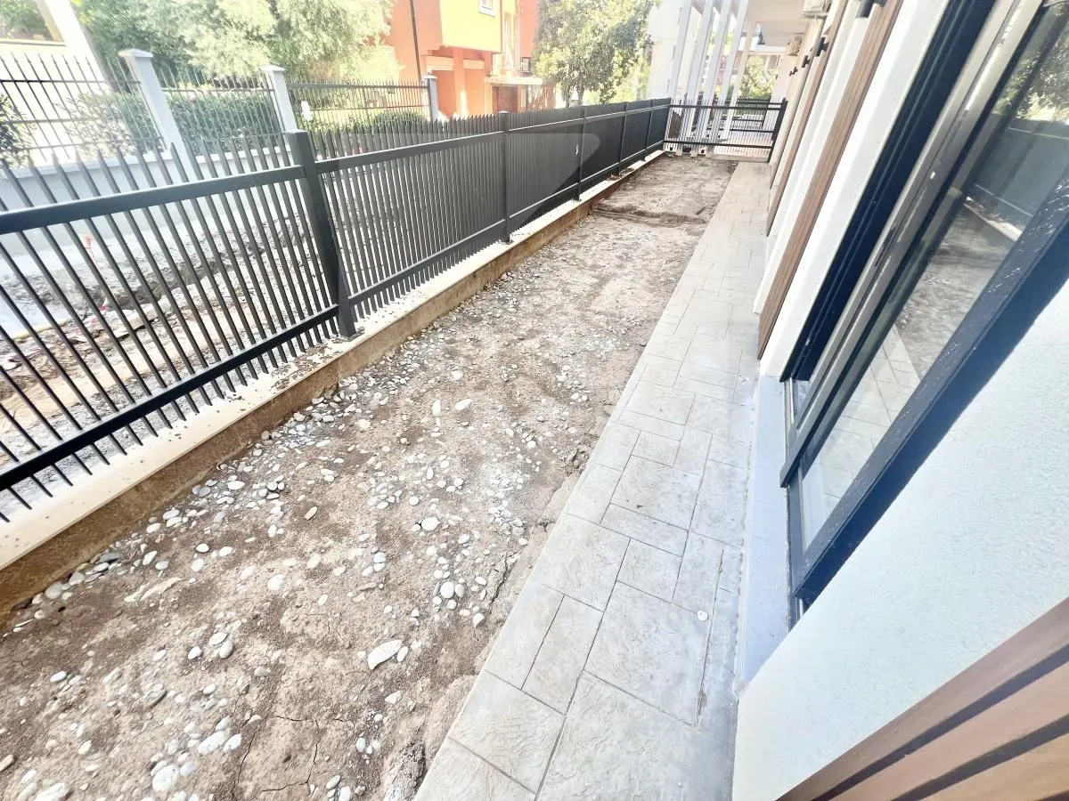 View of the building courtyard with a fence and paved pathways.