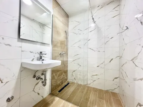 Modern bathroom with a walk-in shower, washbasin, and mirror. - image 7