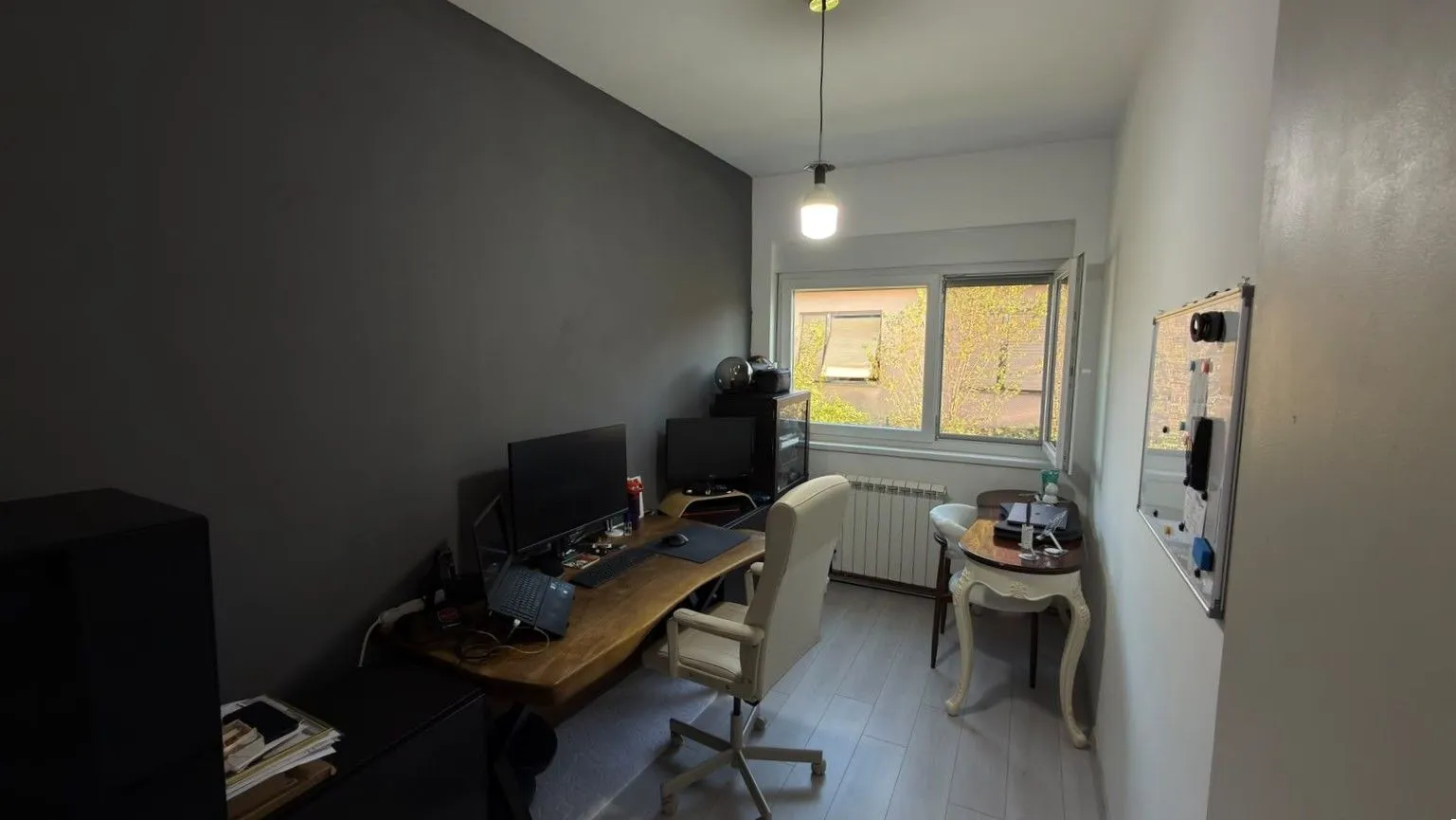 Radna soba sa stolom, računarom i stolicom.
