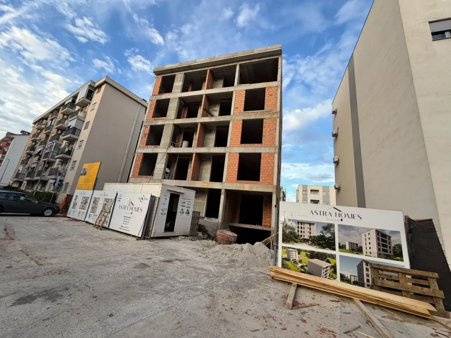 Stambena zgrada u izgradnji sa tablom investitora na gradilištu.