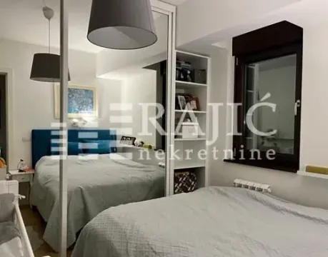 Modern bedroom with a double bed, mirrored wardrobe, and shelves. - image 12