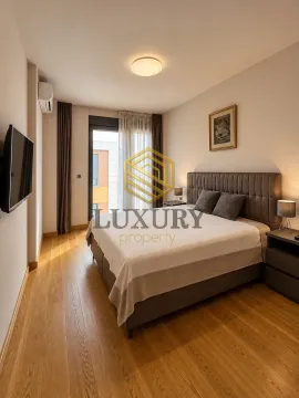 Modern bedroom with a double bed, wooden floor, and access to the terrace. - image 6