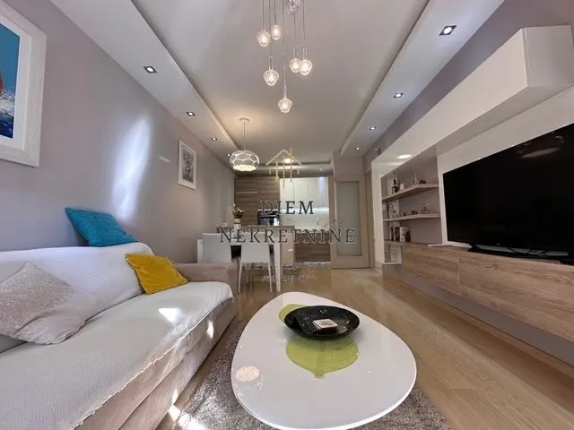 Modern and bright living room with a sofa and dining area in the background.
